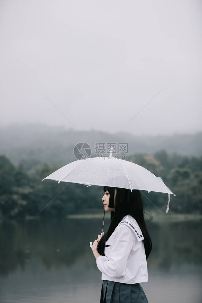 雨天在湖边拿着雨伞看着亚洲图片