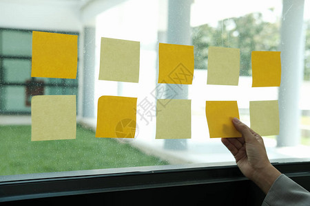 在工作场所的玻璃墙上挂着胶纸粘贴笔纸提醒有创意的想法和企业集思图片