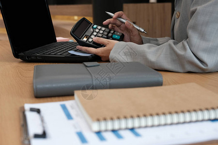 财务顾问在办公室使用计算器会计做会计和算收入和预算簿记员进行计算金图片