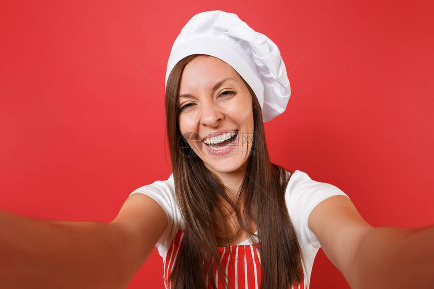 穿着条纹围裙白色T恤衫脱红墙背景孤立的女主妇厨师或面包师关闭自拍女管家近身女管家图片
