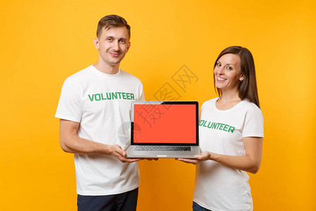 身穿白色T恤衫的男女同事一对志工持有膝上型笔记本电脑图片