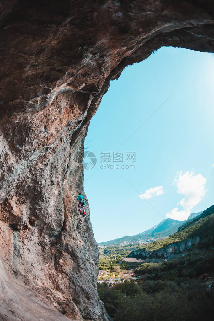 一个女人爬上岩石在大自然中攀爬户外健身积极的生活方式极限运动运动员在自然浮雕上训练在风景如画的地方训练图片