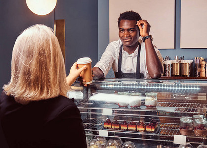 非裔美国人的咖啡店在时尚咖啡店给他的女客户喝咖啡图片