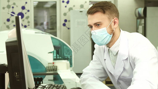 实验室助理在实验室他仔细地看着上的东西他按下键并背景图片