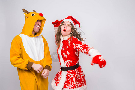 假日圣诞节和有趣的概念穿着鹿服装和服装的滑稽夫妇在白图片