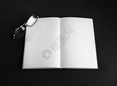 黑色背景的开放书和眼镜空白反图片