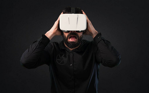 留着胡子的帅哥在黑色背景上使用VR眼镜图片