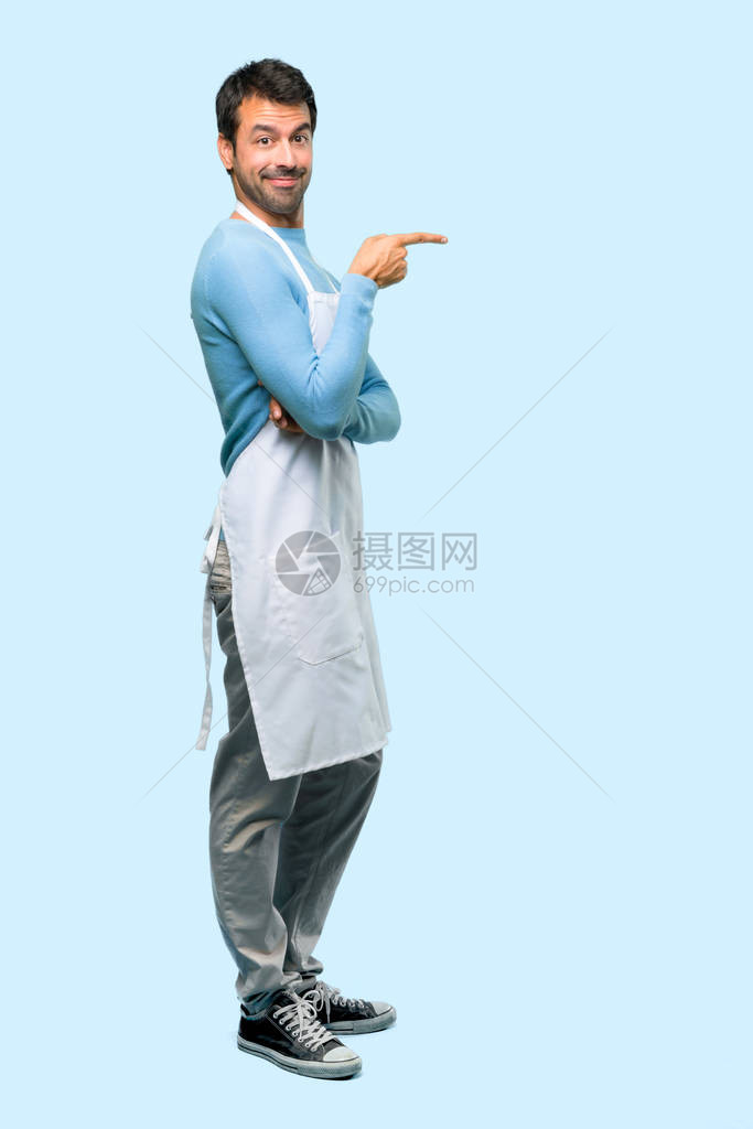 身穿围裙指对着另一侧并用蓝色背景横向姿势展示产品的人全图片