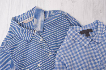 木制背景的蓝条纹和格色衬衫A图片