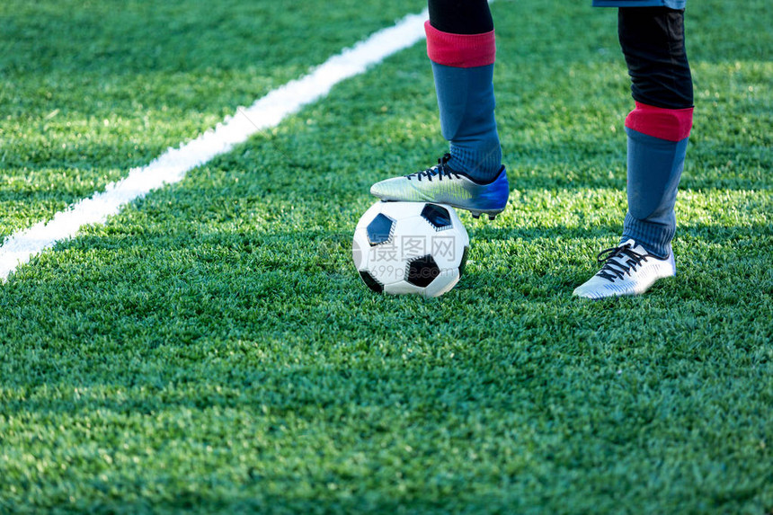经典的黑白足球场上的绿草和运动鞋的腿上足球比赛训练爱好概念图片