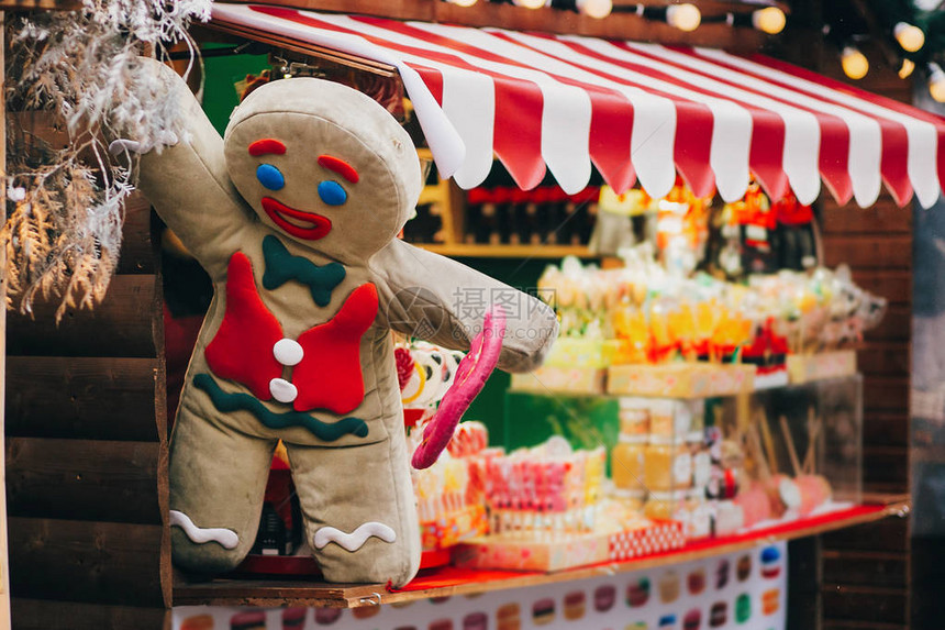 姜饼人与圣诞市场小屋上的棒糖欧洲城市街道上的寒假集市糖果店市中心的节日装饰图片