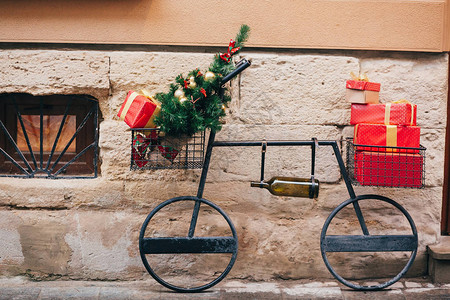 欧洲城市街道上带圣诞树红色礼物酒瓶的创意自行车图片
