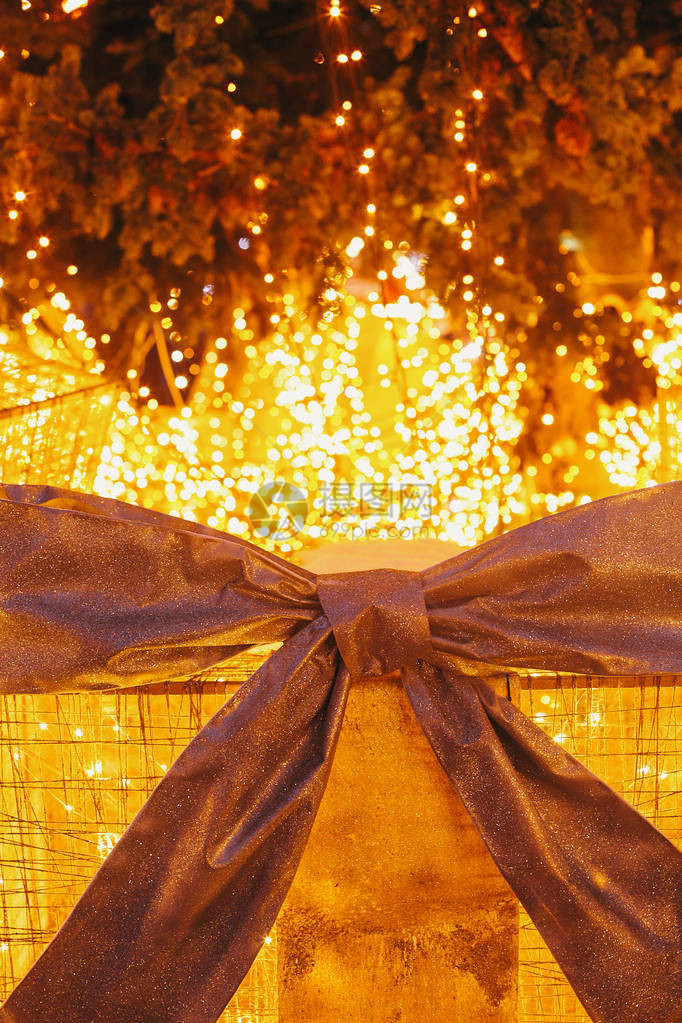 晚上欧洲市中心圣诞树下带灯的礼盒带有蝴蝶结和灯光背景照明的大礼物寒图片