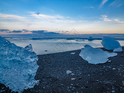 冰山漂浮在Jokulsarlon冰川环礁湖海滩附近图片