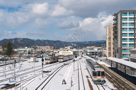 雪天在日本高山站的铁路上的火车图片