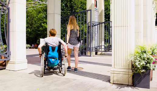 坐在轮椅上的年轻残疾男子与妻子一起图片