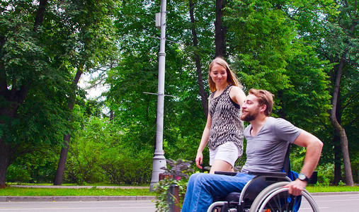 坐在轮椅上快乐的残疾青年男子与妻子一起图片
