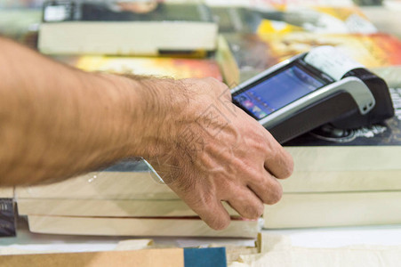 关闭使用信卡刷机支付的男手在书店的POS机中输入信图片