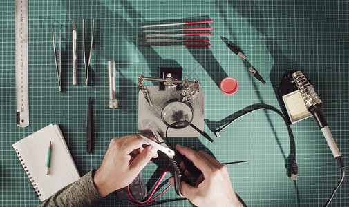 修理电子装置的电线一个男人用手剪一根电线图片