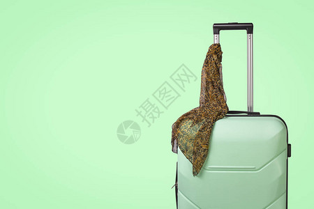 塑料旅行箱和绿色背景上的围巾把手旅行商务旅行探图片