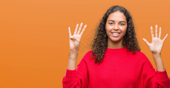 身穿红色毛衣的年轻西班牙女人带着9号指着手指满脸自信和图片