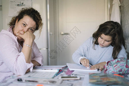 母亲帮助女儿做功课的家图片