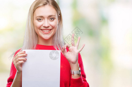 年轻的金发女子拿着空白纸片在孤立的背景上用手指做好手势图片