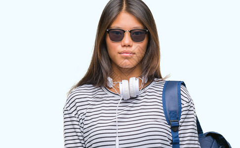 年轻女学生戴耳机和背包图片