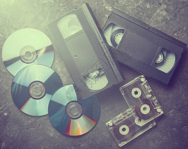 从90年代开始的娱乐和媒体技术CD录音带在黑混凝土表面的录相图片