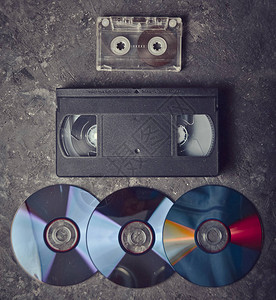 黑色混凝土表面上的平躺录像带CD录音带过去的复古媒体背景图片