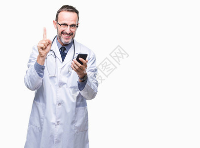 中年老白发医生在孤立的背景下使用智能手机发短信图片