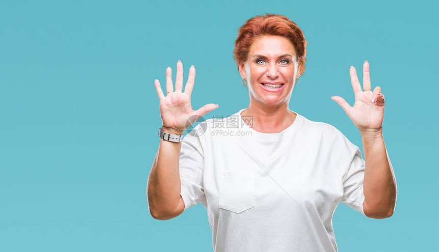 Atrracting高级caucasian红发女人在孤立的背景展示用手指着八号的手指微图片