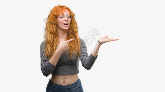 年轻红发女青年在用手和指展示时对镜头大图片