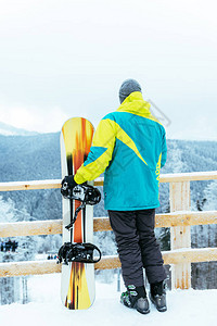 男子站在白雪皑的山顶滑雪板图片
