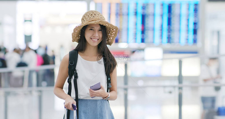 拿着手机微笑对着镜头的女人图片