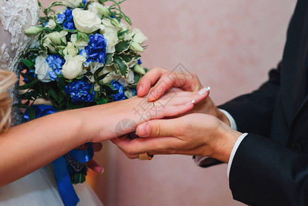 新郎在新娘手上戴结婚戒指作为家庭传图片