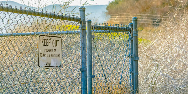 oc在加利福尼亚州圣克莱门特的网状栅栏上禁止标志加利福尼亚州圣克莱门特的OC废物和回收物业的网状铁丝网上的禁止进入标志在栅栏外可以看背景