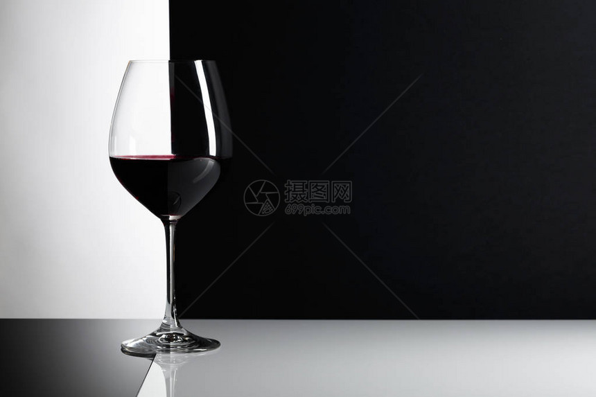 反射背景上的红葡萄酒杯复图片