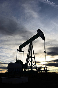 日落时工作的石油和天然气工业泵千斤顶的剪影图像图片