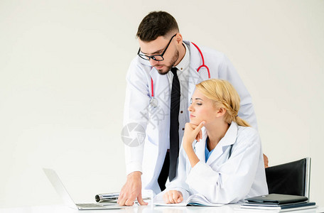 医院办公室的医生在桌上的笔记本电脑上工作图片