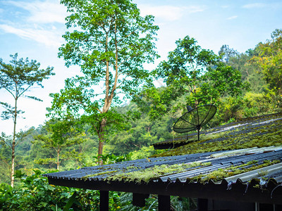 卫星在古老的屋顶上覆盖着青蓝天空背景的山丘附近的雨图片