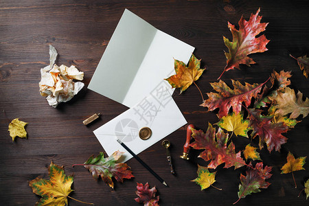空白信封密封蜡明信片邮票铅笔勺子和秋叶树图片