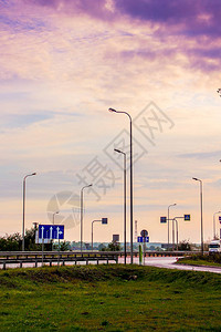 在日出期间的早晨沿途有灯笼和路标的柱子图片