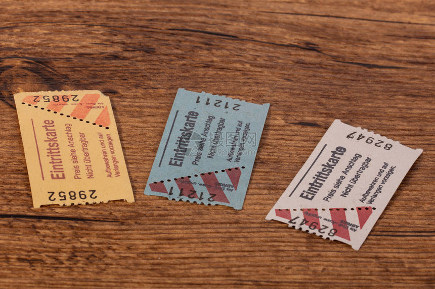 木桌上的三张纸票门票图片