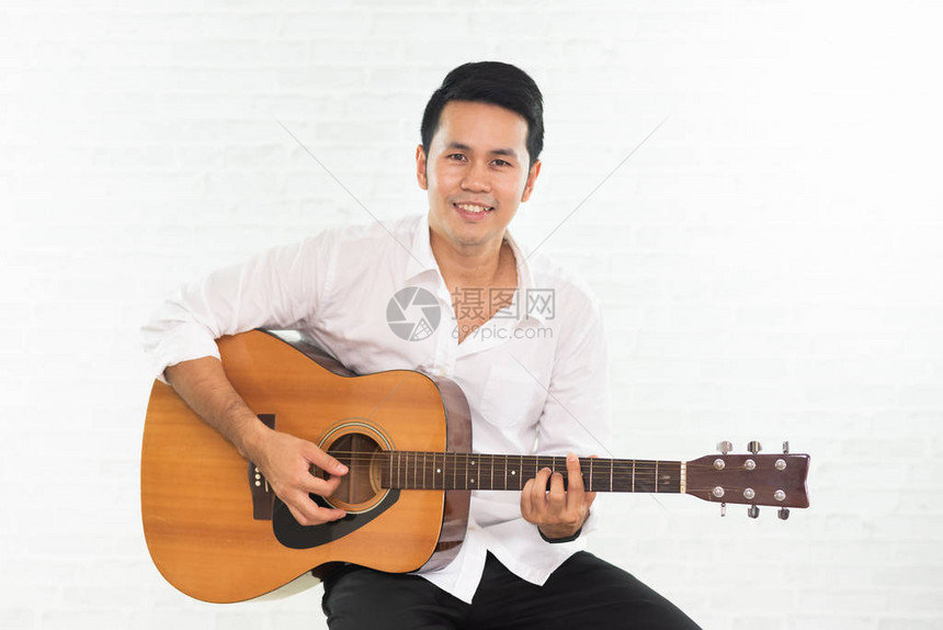 白色背景下弹吉他的男人图片