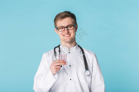 男医生展示粉红药片年轻医生携带蓝底药物图片