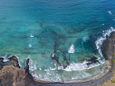 与海浪和冲浪者的水晶般清澈的大海的鸟瞰图普拉亚德拉坎特里亚大西洋背景图片