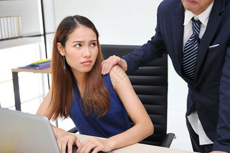 愤怒的不高兴的亚洲秘书看着手的老板在工作场所摸肩膀的女人在办图片