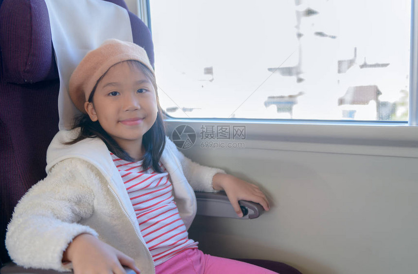 可爱的小女孩笑着坐在火车图片