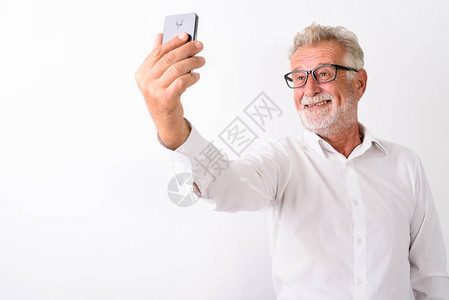 电影演播室拍摄了快乐的长胡子老人在用手机拍自时微笑的照片图片
